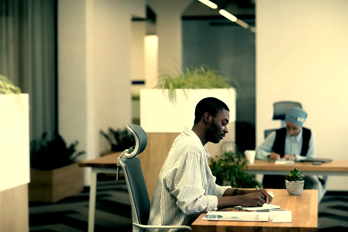 One person working alone at a desk in a quiet Lagos workspace at the end of the day